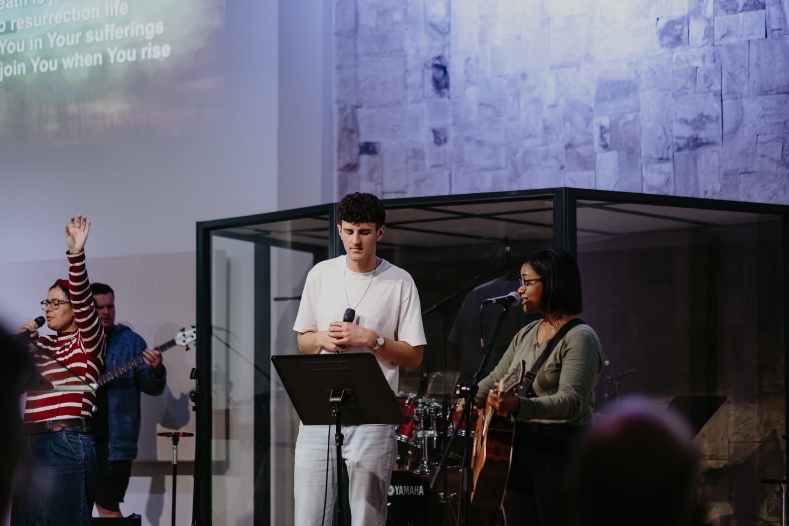 Immerse worship band leading a song on stage as lyrics play behind them