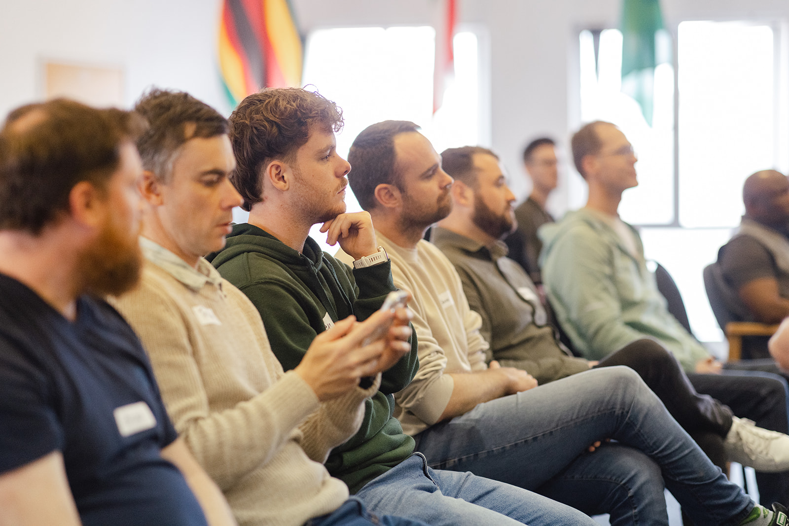 A row of men listening intently during a session