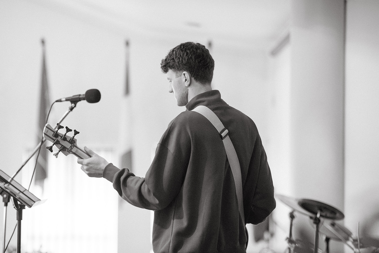 Bass player leading from the stage, in black and white